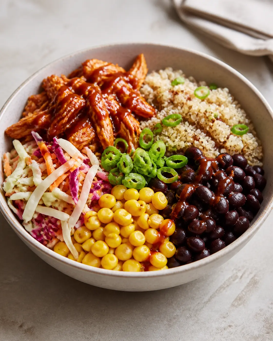 BBQ chicken quinoa bowls with black beans, corn, crunchy slaw, and scallions
