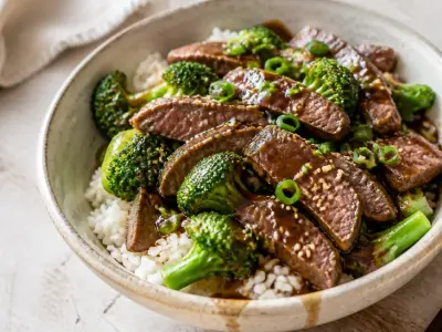 Beef and broccoli rice bowls with glossy garlic ginger sauce and sliced scallions