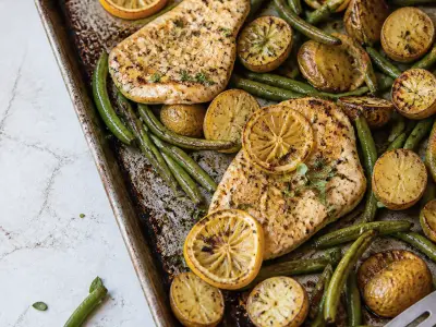 Lemon garlic chicken cutlets with roasted baby potatoes and green beans on a sheet pan
